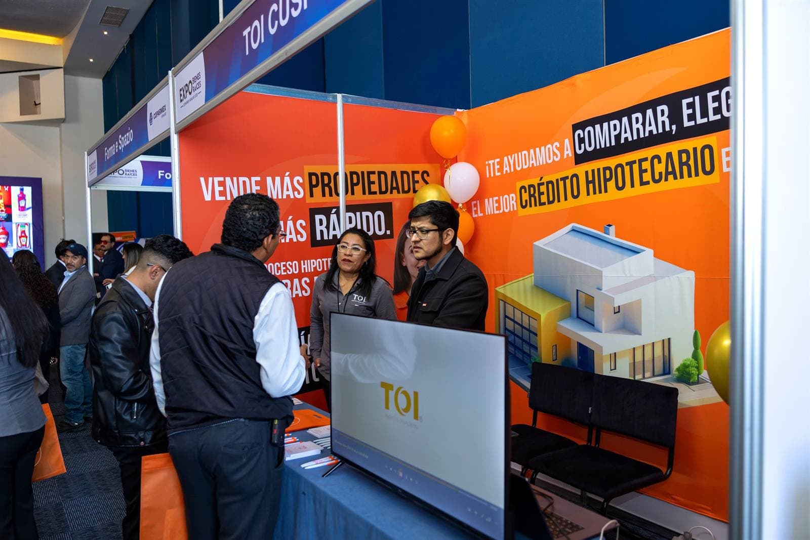 Visitantes recibiendo asesoría sobre crédito hipotecario en un stand